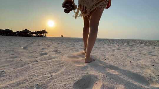 美女光脚走在沙滩上