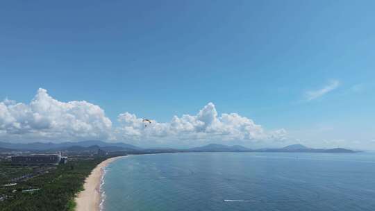 航拍三亚海棠湾蓝天白云动力伞直升机海岸线