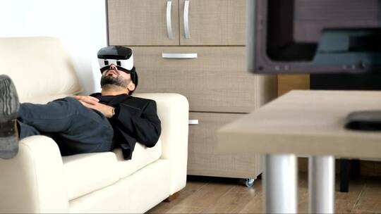 未来人在沙发上用虚拟现实耳机工作视频素材模板下载