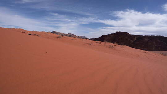 从沙丘下山看到的山脉和沙草