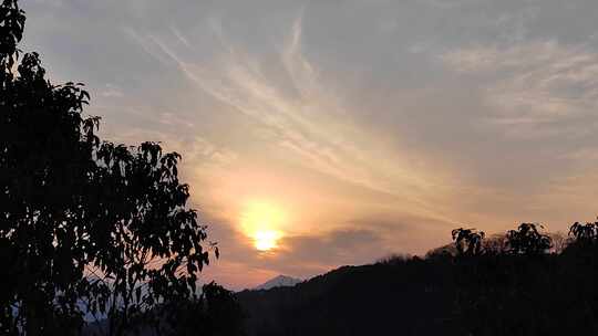 山间日出景象，阳光洒在树木与山峦上