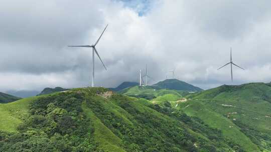 绿色山丘上的风力发电机群全景