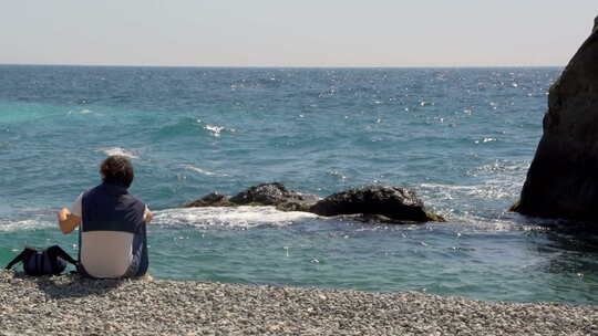 坐在海边看海的年轻人