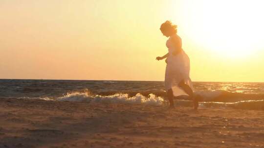 夕阳下，在沙滩上奔跑的连衣裙美女