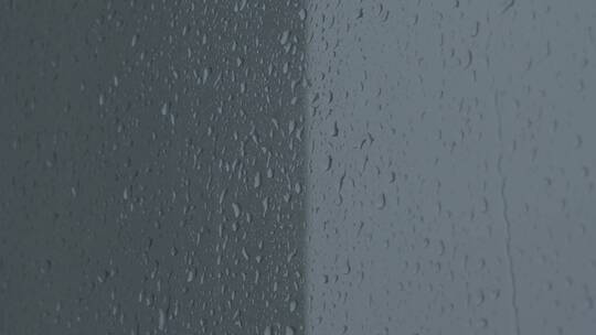下雨天拍摄的窗户玻璃上水珠滴落素材