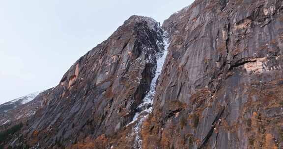 岩石山体景象，缝隙间有积雪覆盖