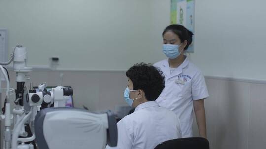 医院验光师给顾客进行眼部验光检查配镜