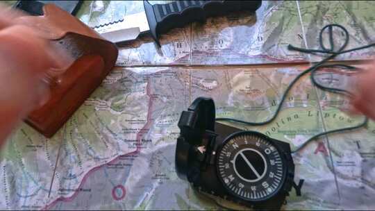 希奇克准备在山上徒步旅行，用指南针、铅笔和刀分析地图