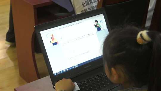 小女孩使用笔记本电脑学习