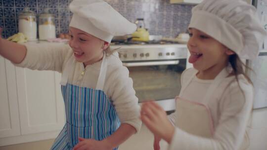 两个小女孩在厨房玩面粉
