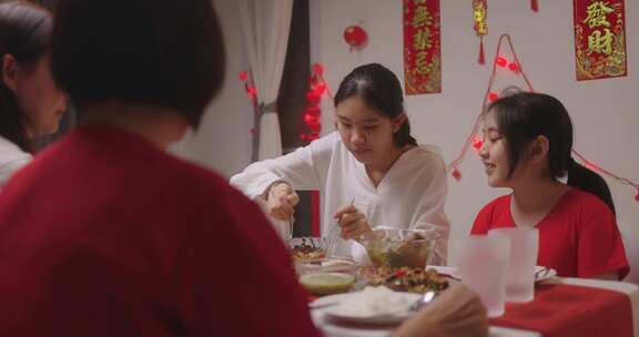 快乐的中国家庭为中国新年庆祝吃晚餐。