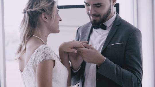 新郎为新娘戴上结婚戒指并亲吻新娘的手慢镜头