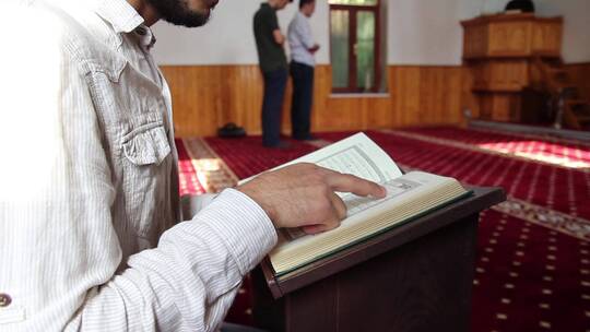 年轻的穆斯林男子在清真寺阅读古兰经