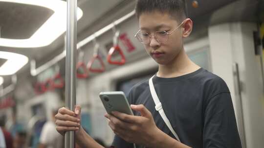 男生在地铁站看手机视频素材模板下载