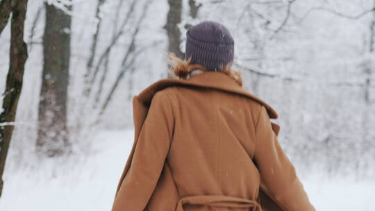 女人在下雪的公园里奔跑