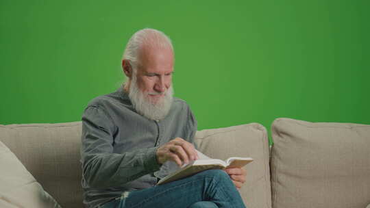 一位老人坐在沙发上看书的绿屏肖像