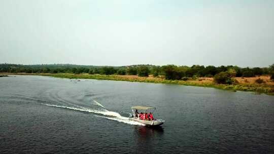 救生衣中的游客在湖中乘坐快艇，在非洲乘船旅行。-空中