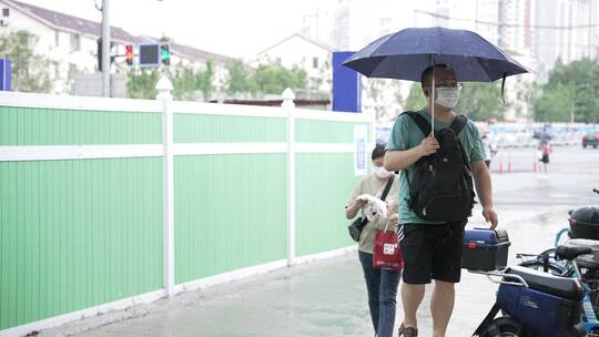 娄山关路雨天撑伞的人