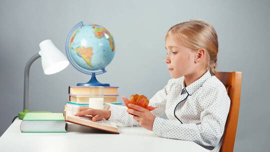 边吃面包边看书的女孩视频素材模板下载
