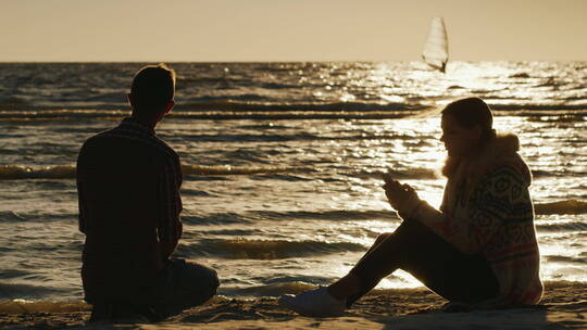 日落时在海滩上放松的夫妇