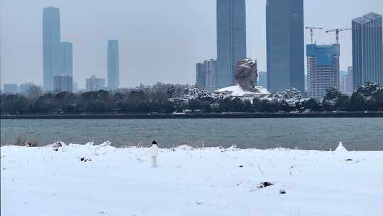 美女雪中行走在湘江边遥望橘子洲