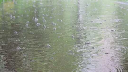 暴雨雨滴落在路面积水溅起涟漪波纹水花水泡