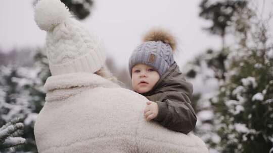 母亲和孩子在雪地上行走