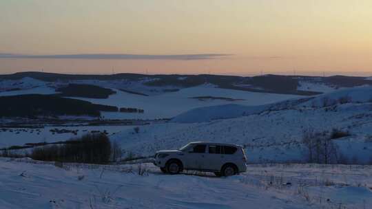 日出环绕航拍雪地下的车辆