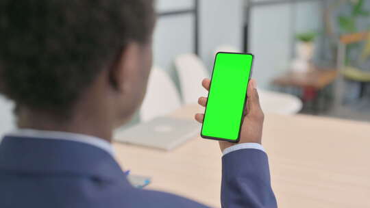 使用绿屏智能手机的年轻商人