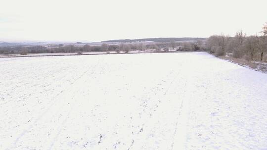 无人机在白雪覆盖的科茨沃尔德田野上空飞行
