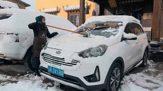 云南景点香格里拉藏区游客打扫汽车积雪