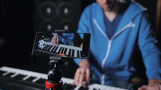 一位专业钢琴演奏家正在用他的手机记录他的视频素材模板下载