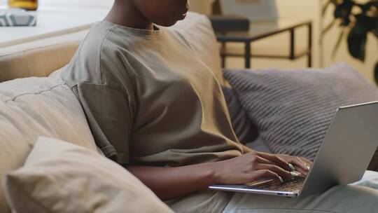 非洲女人坐在沙发上用电脑办公