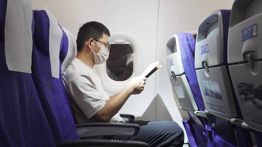 疫情期间男子在飞机上看书学习