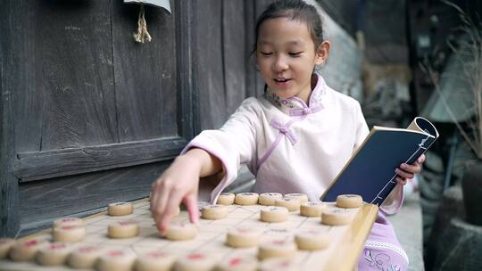 穿中国传统服饰下中国象棋的中国女孩