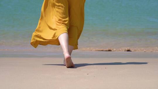 一个黄裙子美女在海边散步的脚步