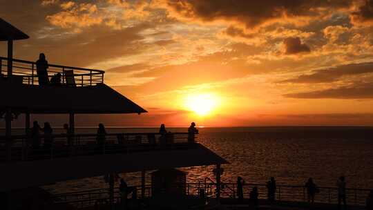 邮轮船舷上的游客夕阳剪影