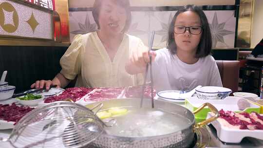 4K实拍升格吃潮汕牛肉火锅的母女两个人视频素材模板下载