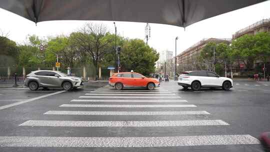 下雨天打伞在上海市龙川北路过横道斑马线