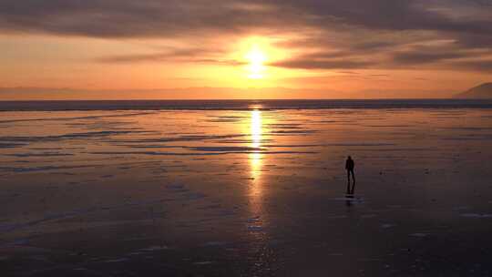 日落时分贝加尔湖冰上溜冰者的剪影。顶部角