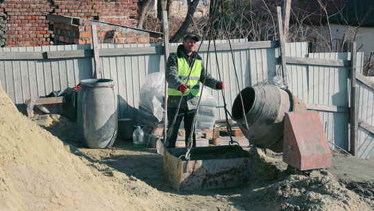 建筑工地准备水泥的工人穿着高能见度背心和