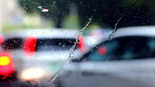 雨中对焦前挡拍摄的玻璃雨幕和前方虚化车尾