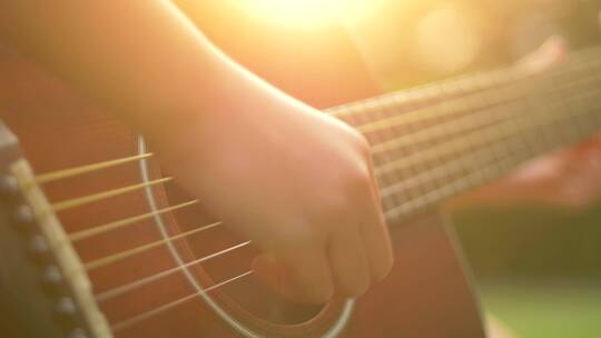 孩子在夕阳下弹吉他，琴弦特写视频素材视频素材模板下载