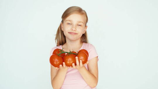 小女孩捧着西红柿微笑视频素材模板下载