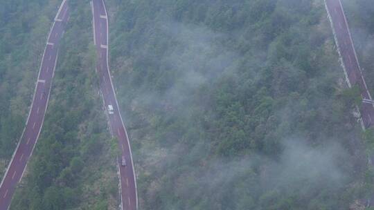雨雾天汽车行驶在矮寨大桥的盘山公路上