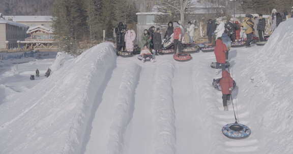 雪地中玩雪圈的欢乐人群