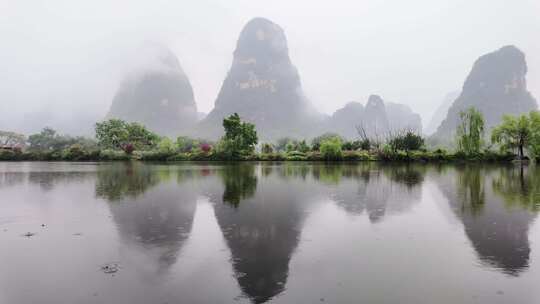 雨天湖景倒映绿树青山的宁静画面