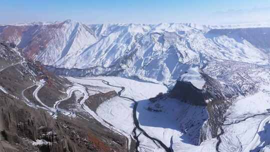 航拍新疆冬季安集海大峡谷红色山脉雪山河流