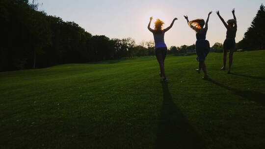女性迎着阳光在草坪上奔跑
