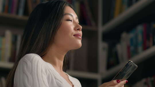 亚裔女女少数民族女学生在大学图书馆书架上视频素材模板下载